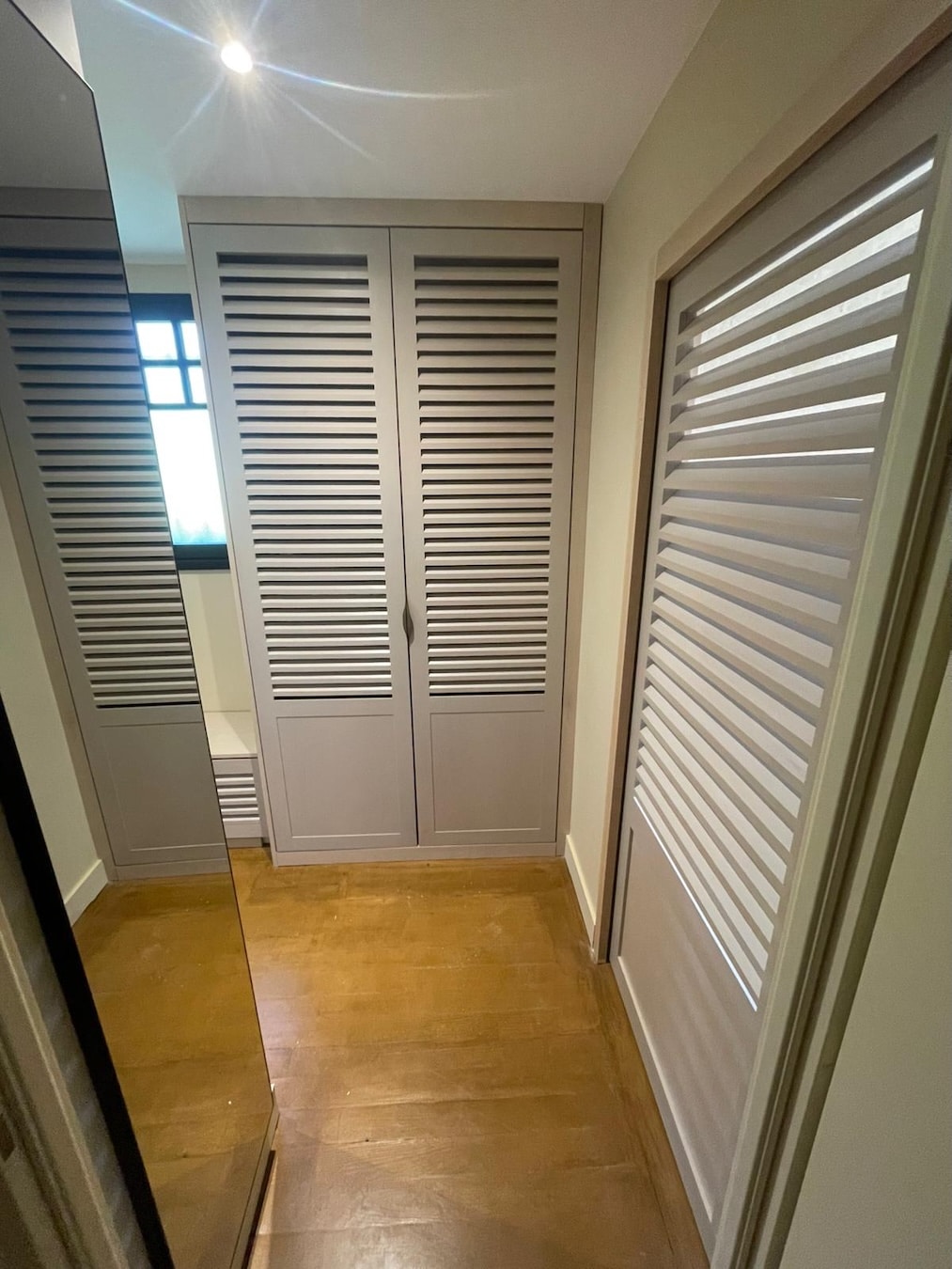 Aménagement intérieur : portes de placard persiennes sur-mesure au Pyla-sur-Mer (33115) 1 Placards à portes persiennes sur mesure en hêtre, dégagement avec miroir au Pyla-sur-Mer